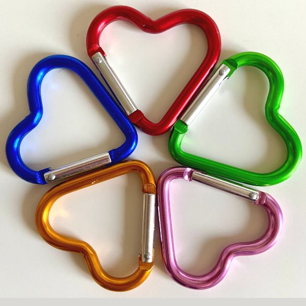 Cinq mousquetons en forme de coeur de couleur rose, rouge, orange, vert et bleu sont disposés en rond comme une étoile. Mousqueton coeur Youyou Doudou photo personnalisé enfant doudou parent papa maman famille bebe fille garcon jouet doudou calin réconfort